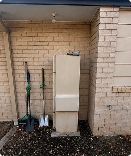 Before: old hot water system at a Logan home