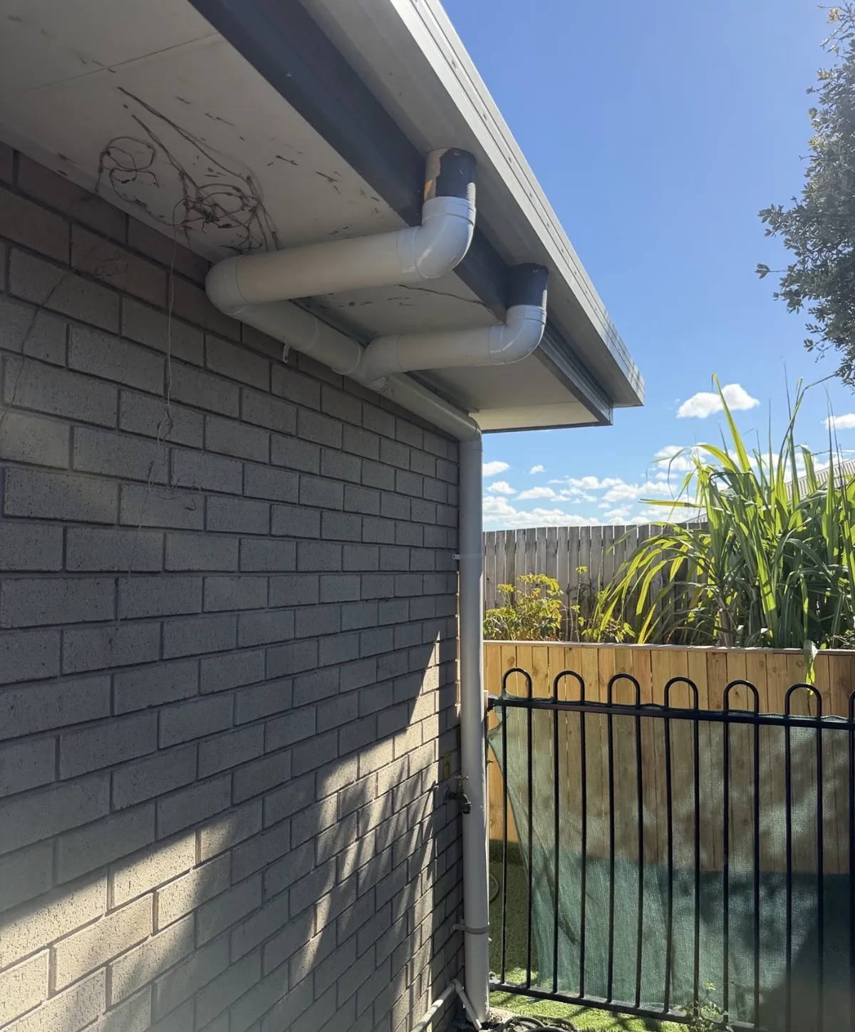 Before and after of a downpipe and stormwater connection repair