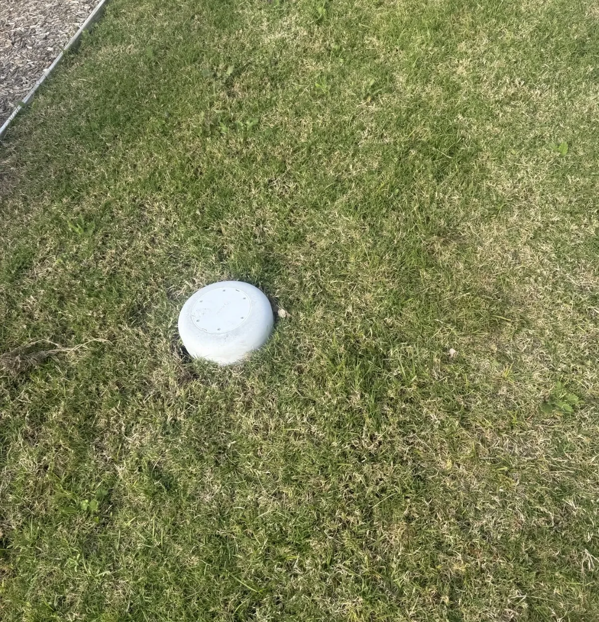 New sewer inspection opening cap installed in a lawn